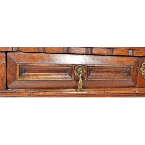 421 - A 17th Century Jacobean solid carved oak chest of drawers having chamfered edge top over a configura... 