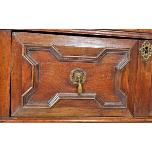 421 - A 17th Century Jacobean solid carved oak chest of drawers having chamfered edge top over a configura... 