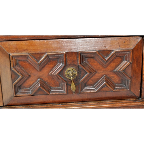 421 - A 17th Century Jacobean solid carved oak chest of drawers having chamfered edge top over a configura... 