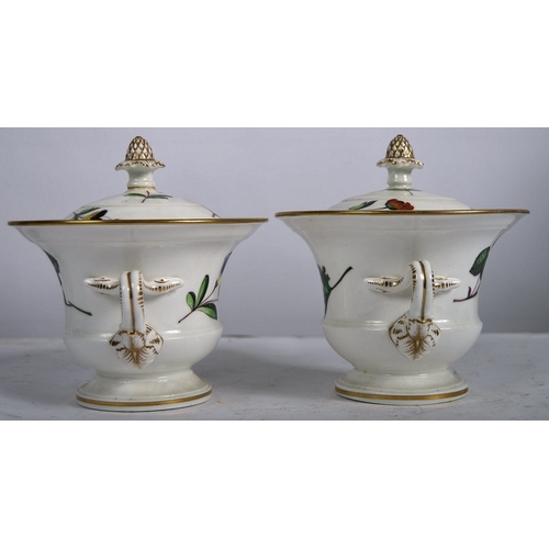 439 - A pair of 19th Century porcelain lidded urns. Acorn finial tops with hand painted floral decoration,... 