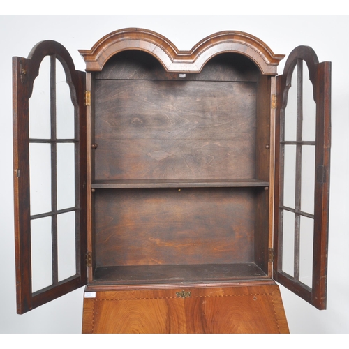 443 - A 20th Century Queen Anne style double dome walnut bureau bookcase having a twin arched top bookcase... 