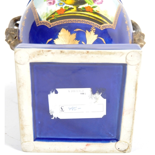 445 - An early 20th Century continental porcelain lidded urn in the Dresden style, having a deep cobalt gr... 