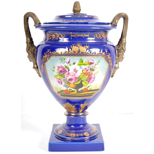 445 - An early 20th Century continental porcelain lidded urn in the Dresden style, having a deep cobalt gr... 