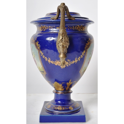 445 - An early 20th Century continental porcelain lidded urn in the Dresden style, having a deep cobalt gr... 