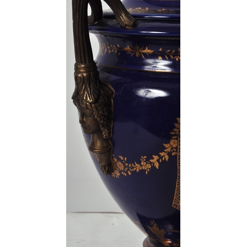 445 - An early 20th Century continental porcelain lidded urn in the Dresden style, having a deep cobalt gr... 