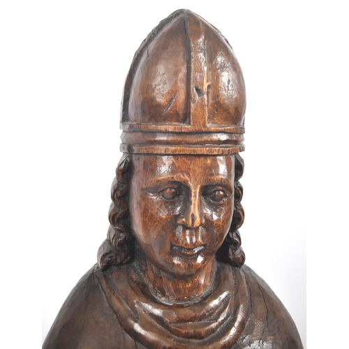 448 - A 19th century oak carving of a religious figure. The ecclesiastical carving depicts a Bishop wearin... 