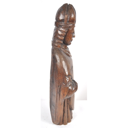 448 - A 19th century oak carving of a religious figure. The ecclesiastical carving depicts a Bishop wearin... 