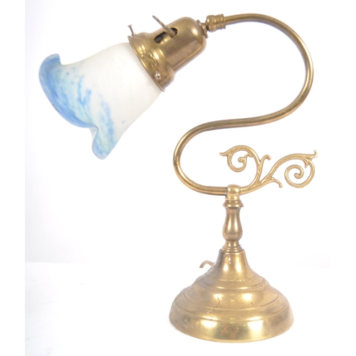 472 - An early 20th Century brass & glass coaching lamp / desk lamp. Coloured glass shade raised on brass ... 