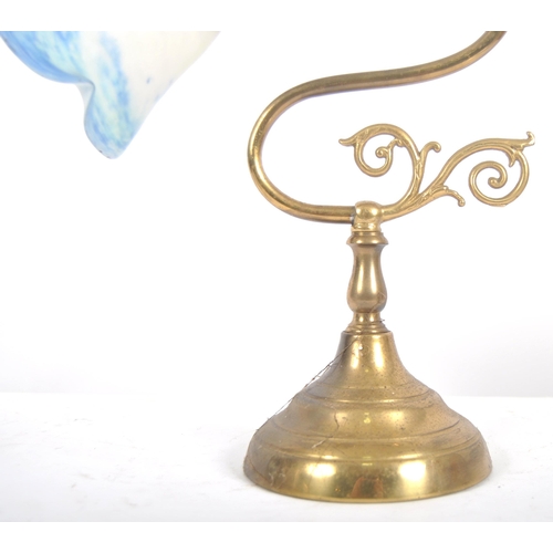 472 - An early 20th Century brass & glass coaching lamp / desk lamp. Coloured glass shade raised on brass ... 