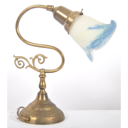 472 - An early 20th Century brass & glass coaching lamp / desk lamp. Coloured glass shade raised on brass ... 