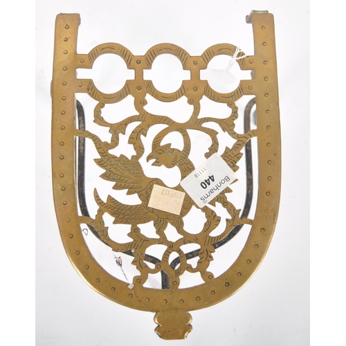 486 - A pair of 18th Century brass and wrought iron trivets / kettle stands. Pierced decorated with engrav... 