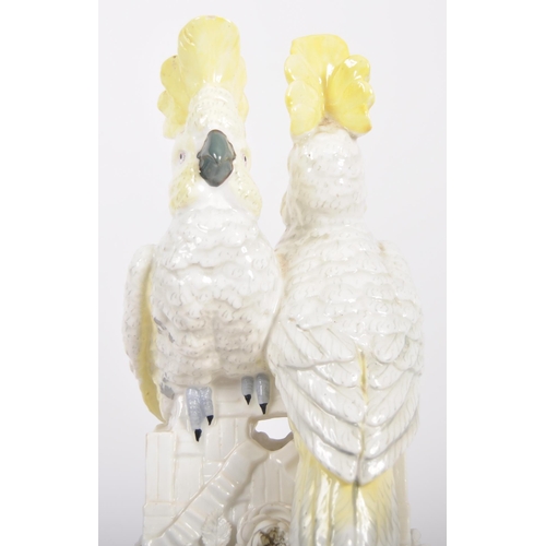 490 - A 19th Century Continental porcelain figurine group depicting a pair of cockatoos mounted on twin wo... 