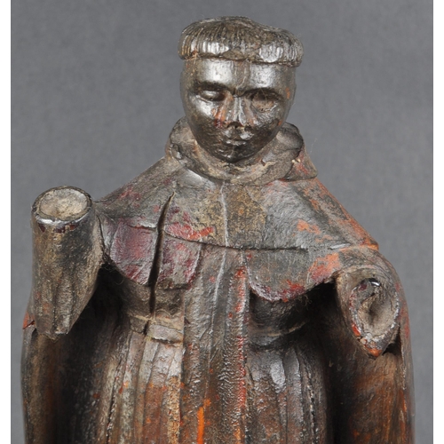 503 - A 19th possibly 18th century walnut carving of a monk. Figure posed as standing on an orb with both ... 