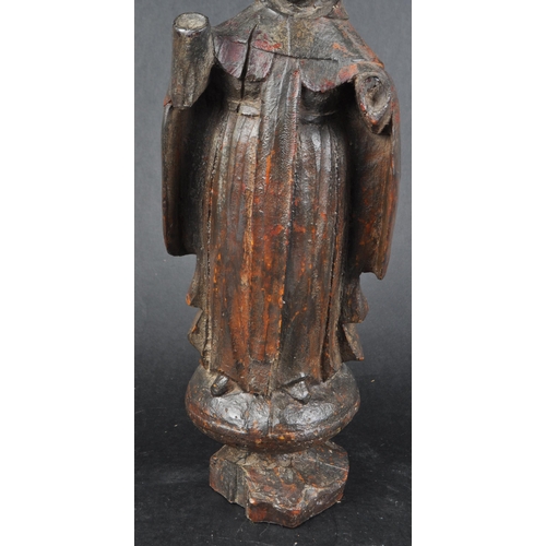 503 - A 19th possibly 18th century walnut carving of a monk. Figure posed as standing on an orb with both ... 