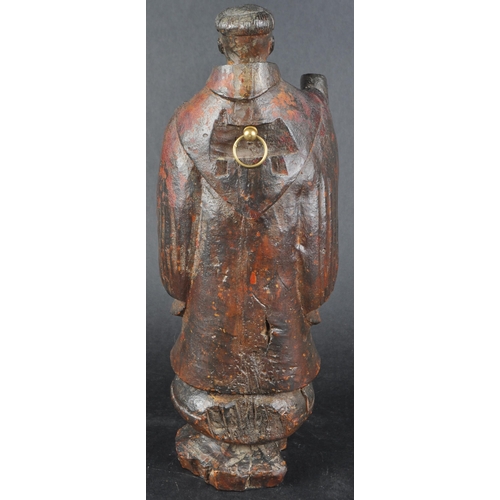 503 - A 19th possibly 18th century walnut carving of a monk. Figure posed as standing on an orb with both ... 