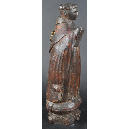 503 - A 19th possibly 18th century walnut carving of a monk. Figure posed as standing on an orb with both ... 