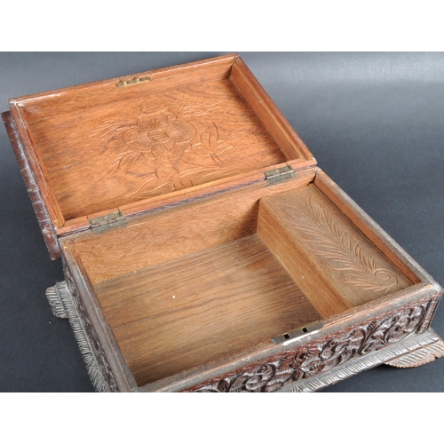 511 - A 19th Century carved Anglo-Indian colonial workbox / jewellery box. Carved scrolling leaves and rep... 