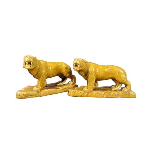 525 - A pair of 19th Century Victorian glazed ceramic tigers with each in a prowling position with mouths ... 