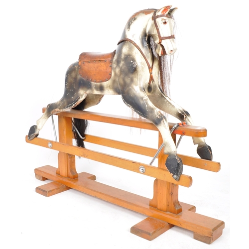 543 - A large 20th Century hand painted rocking horse having leather reins and saddle with faux hair mane ... 