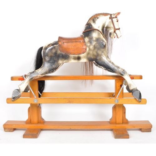 543 - A large 20th Century hand painted rocking horse having leather reins and saddle with faux hair mane ... 