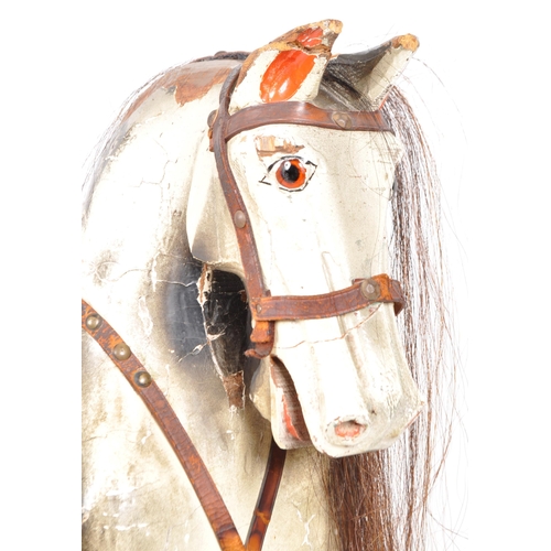 543 - A large 20th Century hand painted rocking horse having leather reins and saddle with faux hair mane ... 