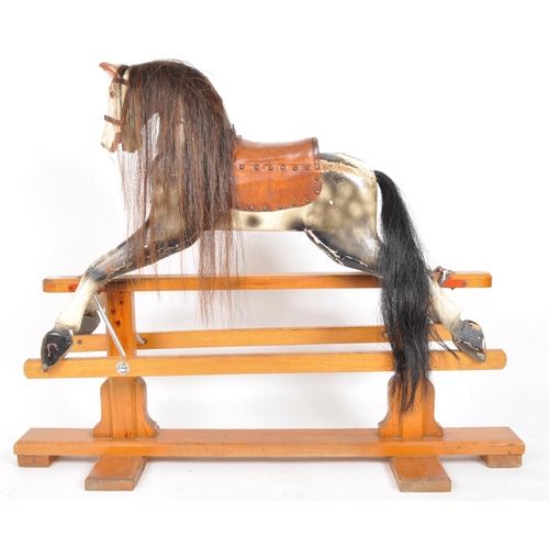 543 - A large 20th Century hand painted rocking horse having leather reins and saddle with faux hair mane ... 