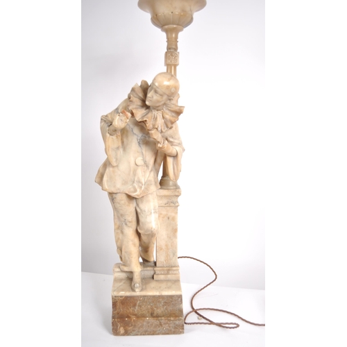 548 - A 20th century marble torchere statue. Depicting a standing Pierrot with a gittern under his arm lea... 