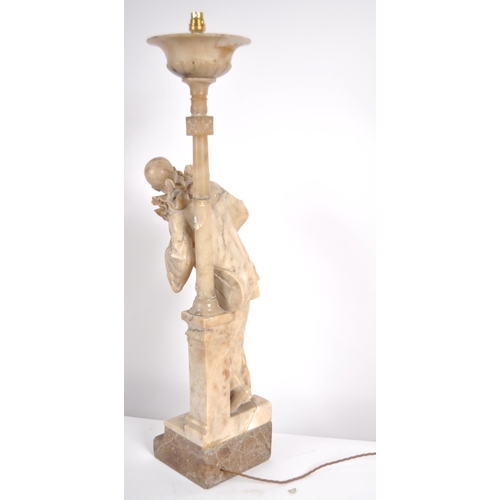 548 - A 20th century marble torchere statue. Depicting a standing Pierrot with a gittern under his arm lea... 