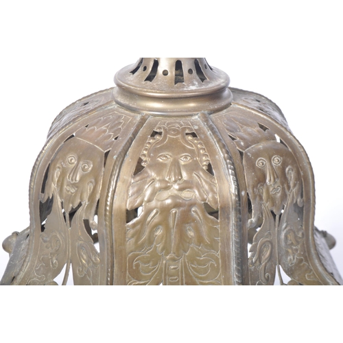 551 - A late 19th Century brass worked hanging lantern having a large hanging hoop atop with embossed face... 