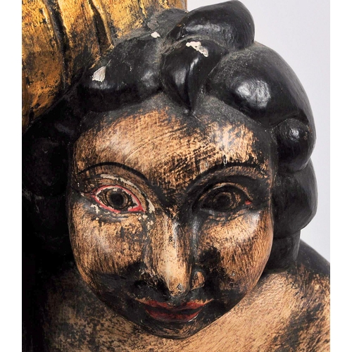 558 - A 20th Century hand carved and painted wooden statue of a cherub holding a torch. Measures approx; 7... 