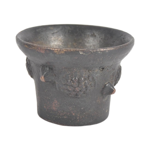 573 - A 17th century bronze miniature poison mortar. Of frustoconical form decorated on the outside with r... 