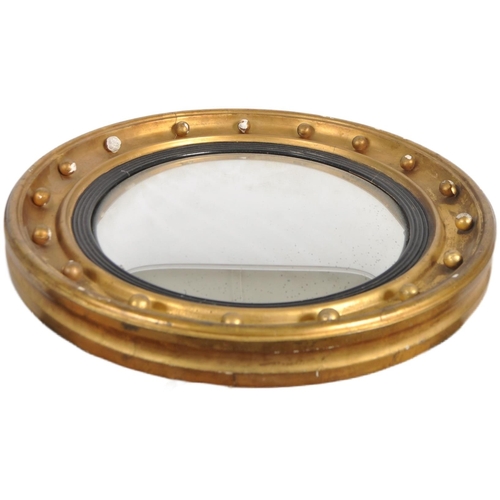 590 - A Regency 19th century gilt wood and gesso worked convex fish eye / wall mirror. The convex mirror g... 