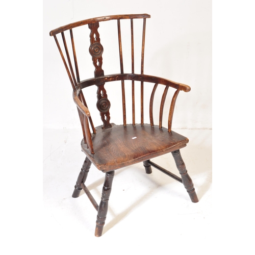 606 - A 19th Century beech & elm comb back Windsor armchair. Central carved domino counter set splat back ... 