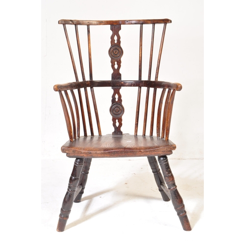 606 - A 19th Century beech & elm comb back Windsor armchair. Central carved domino counter set splat back ... 