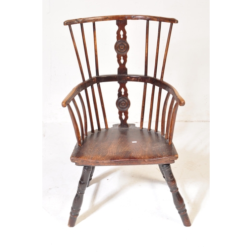 606 - A 19th Century beech & elm comb back Windsor armchair. Central carved domino counter set splat back ... 