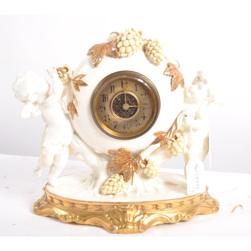 626 - A late 19th century porcelain mantel clock, decorated with cherubs eating grapes on a gilded base. T... 