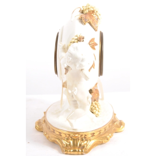 626 - A late 19th century porcelain mantel clock, decorated with cherubs eating grapes on a gilded base. T... 