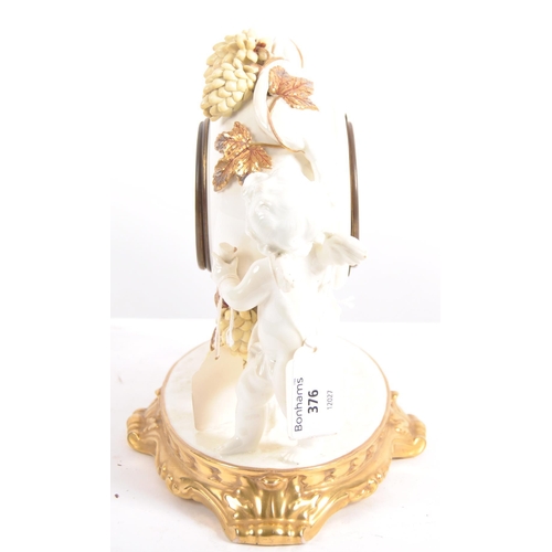 626 - A late 19th century porcelain mantel clock, decorated with cherubs eating grapes on a gilded base. T... 