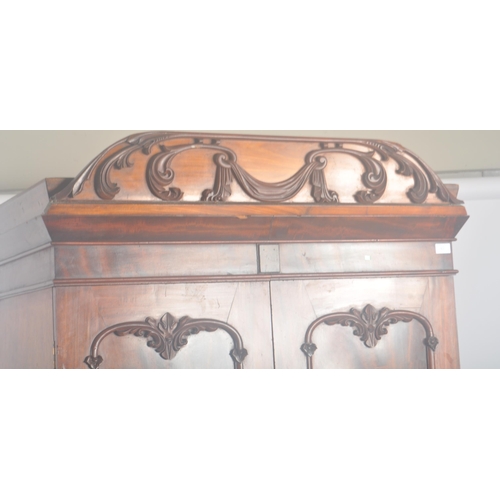 63 - A large 19th Century Victorian mahogany gentlemen's bachelor's wardrobe having a carved pelmet top w... 