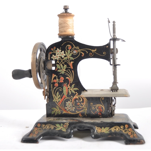 633 - A 19th Century miniature painted tin childs sewing machine along with a small cast iron iron and tri... 