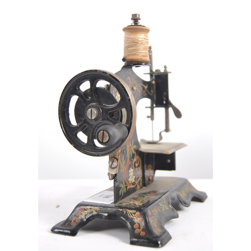 633 - A 19th Century miniature painted tin childs sewing machine along with a small cast iron iron and tri... 