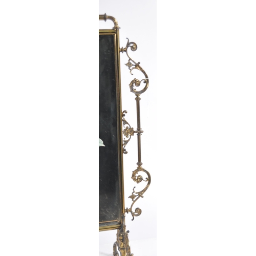 634 - A 19th Century Victorian brass fire screen. Ornate form with scrollwork frame and central glass mirr... 