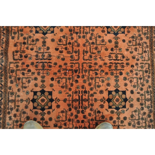 668 - A large early 20th Century Persian Islamic floor carpet rug having a red ground with central panel h... 