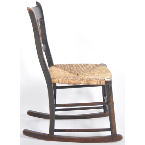 97 - A 19th Century oak child's rocking chair with spindle back having a woven grass seat raised on block... 