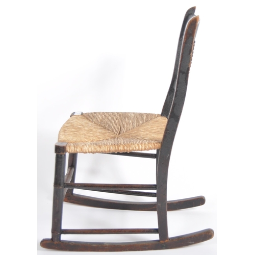 97 - A 19th Century oak child's rocking chair with spindle back having a woven grass seat raised on block... 