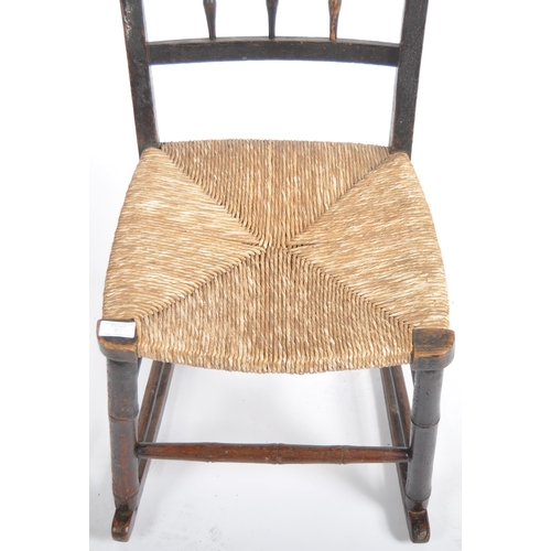 97 - A 19th Century oak child's rocking chair with spindle back having a woven grass seat raised on block... 