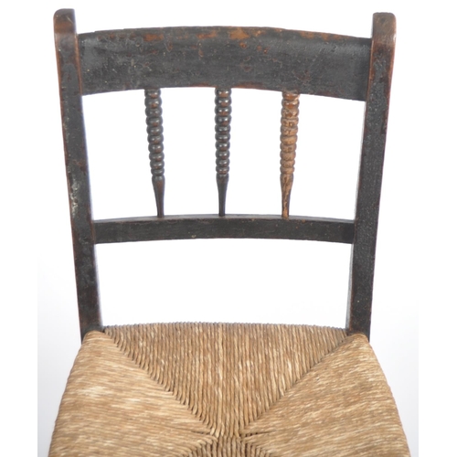 97 - A 19th Century oak child's rocking chair with spindle back having a woven grass seat raised on block... 