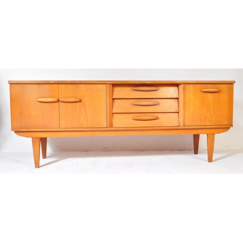 694 - A retro vintage mid 20th century teak sideboard credenza having a central bank of three drawers flan... 
