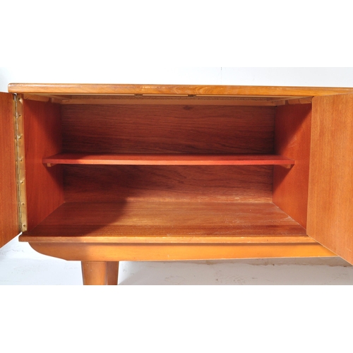 694 - A retro vintage mid 20th century teak sideboard credenza having a central bank of three drawers flan... 