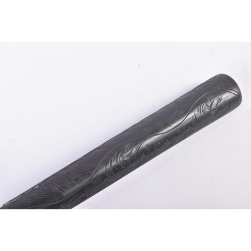 193 - An early 20th century circa 1920s wooden ebonised Chinese police baton with scrolled carving to the ... 